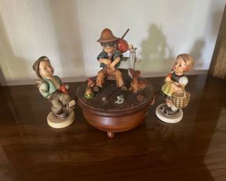 Collection of three vintage Hummels, including two Goebel-style children and a central carved wooden music box depicting a boy playing a flute.