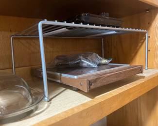 Vintage electric warming tray with wood trim, stored in a cabinet under a wire shelf organizer.