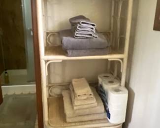 Vintage white rattan and wicker bathroom etagere featuring three display shelves and two bottom drawers.