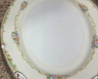 Vintage oval porcelain serving platter featuring a delicate floral motif, cream border, and gilt filigree rim accents.