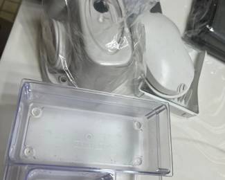 Assorted clear plastic storage organizers shown alongside white and gray plastic home items.