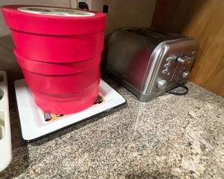 Cuisinart stainless steel four-slice toaster alongside a set of bright pink stackable storage boxes sitting on a white tray.