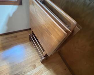 Set of vintage folding wooden TV tray tables stored on a matching wooden rack.