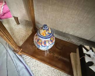 Hand-painted Talavera ceramic ginger jar sitting on the lower wooden shelf of an accent table.