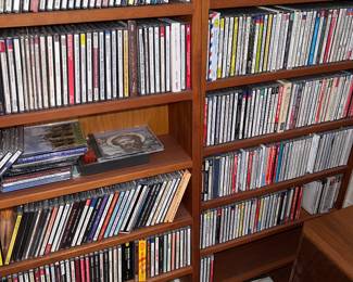 Tall wooden media storage cabinets packed with CD's and other media
