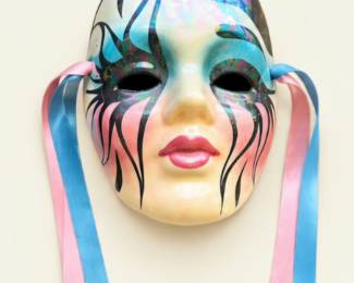 Iridescent decorative masquerade mask featuring colorful painted accents, black swirling designs, and pink and blue ribbons.