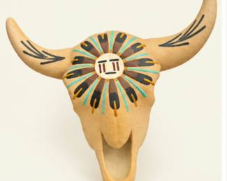 Southwestern-style decorative bull skull with curved horns, textured tan finish, and colorful geometric sunburst design.