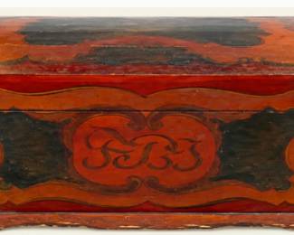 Antique painted wooden storage chest with decorative folk-art detailing, curved lid, and aged red, brown, and black finish.
