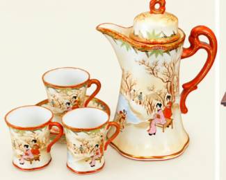 Asian-style porcelain beverage set featuring a lidded serving pot, three matching cups, and saucer. Hand-painted-style figural scenes with orange-red trim.