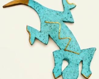 Southwestern-style turquoise wall decoration featuring an abstract animal design, textured finish, and gold-tone accents.