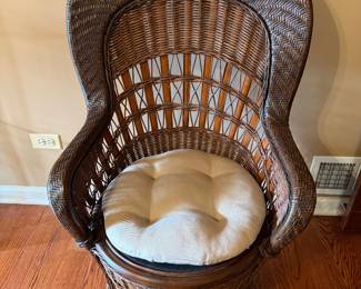High back brown wicker chair with off white pad. 