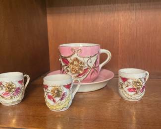Vintage German pink lusterware porcelain teacup and saucer set featuring raised 3D gold painted floral and scroll accents