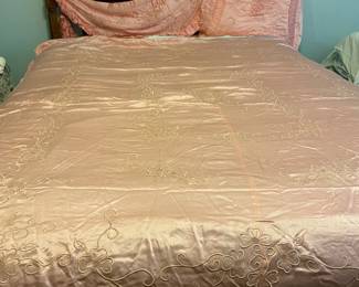 Peach colored satin coverlet. Fits full/queen with matching shams- one is square the other is triangular with tassels