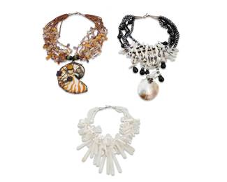 1215 Three Shell and Stone Necklaces Comprising a multistrand necklace with grey pearls and black stone beads with mother-of-pearl shell spacers, and multiple drops including a large shell (17 x 4 1/2 in.), as well as a multistrand necklace with clear bead strands and various shell and stone spacers and tapered drops (17 1/2 x 4 in.), and a multistone beaded necklace suspending a nautilus shell slice pendant with silver wire and gemstone accents (18 x 4 in.), 3 pieces  626.0 grams gross Estimate: $200 - $400