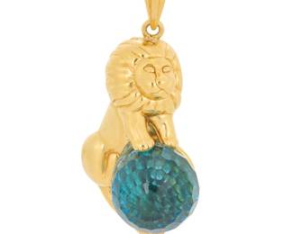 1024 A 14K Gold and Crystal Pendant Of a lion motif set with a faceted blue crystal sphere  Measures: 1 1/2 x 3/4 in. 5.6 grams gross Estimate: $400 - $600