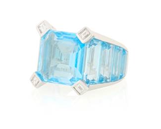 1075 An 18K White Gold, Blue Topaz and Diamond Ring Centering a cut-cornered square step-cut blue topaz flanked by graduated blue topaz baguettes and finished with four diamond set prongs  Size: 6 3/4 13.5 grams gross Estimate: $2,200 - $2,800
