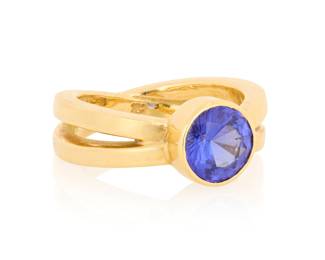 1019 An 18K Gold and Tanzanite Ring Centering a round tanzanite, set in a criss cross mount, marked MS  Size: 8 12.0 grams gross Estimate: $1,500 - $2,000