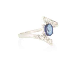 1067 An 18K White Gold, Sapphire and Diamond Ring Centering an oval sapphire weighing approximately 0.90 carat accented by round and single-cut diamonds set in a bypass design  Size: 8 3/4 3.5 grams gross Estimate: $1,000 - $1,500