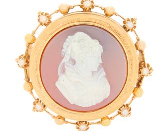 1017 An 18K Gold and Cameo Brooch Centering a carved sardonyx cameo set in an ornate frame accented by seed pearls  Measures: 1 1/4 in. 8.7 grams gross Estimate: $600 - $800