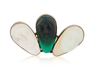 1011 A Glass Brooch Featuring three green, colorless and milky molded glass faces  Measures: 2 1/4 x 1 1/4 in. 24.9 grams gross Estimate: $300 - $500