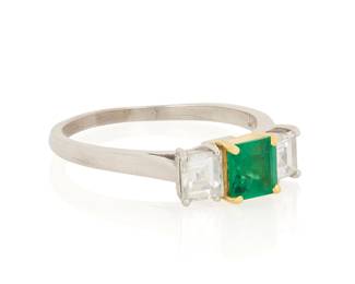1032 A Platinum, Gold, Emerald and Diamond Ring Centering a square step-cut emerald flanked by two square step-cut diamonds, no.23691  Size: 7 1/4 4.4 gram gross Estimate: $800 - $1,200