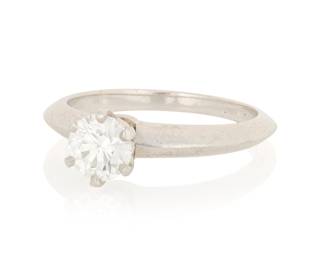 1073 Tiffany & Co.: A Platinum and Diamond Ring Centering a single round diamond weighing approximately 0.68 carat, signed Tiffany & Co., 19816389, with signed box  Size: 6 4.7 grams gross Estimate: $1,800 - $2,200