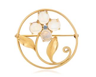 1163 A 14K Gold and Moonstone Brooch Featuring a scrolling floral design set with oval moonstone cabochons and a single round blue topaz  Measures: 1 1/2 in. 7.4 grams gross Estimate: $600 - $800