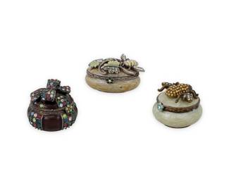 1219 Jay Strongwater: A Group of Jewel Encrusted Trinket Boxes Comprising three diminutive polychrome enameled and Swarovski crystal-mounted trinket boxes, each with figural motif including a large bumblebee, a bee on a twining branch, and a multicolored bow and ribbon, two signed to plaque on base 3 pieces  Each: 1 in. H; 1 1/2 in. W & 1 1/4 in. Dia. 128.6 grams gross Estimate: $200 - $300