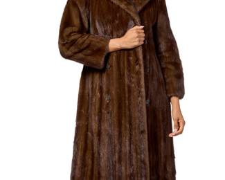 1257 Birger Christensen: A Demi Buff Brown Mink Coat Circa 2010s or earlier The double breasted long coat with notched collar, buttoned half-belt to back, horn buttons, two slash pockets with brown velvet lining, and the interior with a brown Bemberg-style lining, interior slash pocket with embroidered monogram and narrow self-fabric ties at one side seam Label: Birger Christensen / Copenhagen / Made in Denmark  No size label; back width at shoulders: 14 in.; back width at underarms: 21 in.; sleeves: 23 in.; length: 45 in. Estimate: $300 - $500