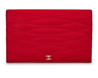 1222 CHANEL: A Vintage Quilted Red Satin Clutch Circa 1990s or later, France A flat wallet clutch in red satin, with gold-tone CC to front flap, overall oval quilted pattern to exterior, and the interior with large coin purse, large zip pocket and multiple slip-in pockets Marked to interior: Chanel / ® / Made in France  5 x 8 x 3/4 in. Estimate: $400 - $600