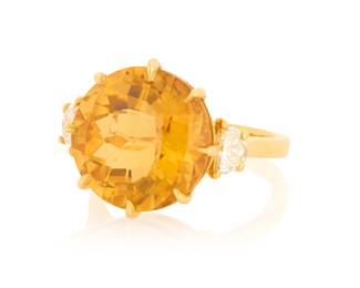 1172 An 18K Gold, Citrine and Diamond Ring Centering a round mixed-cut citrine measuring approximately 13.81 x 13.90 x 9.53 mm, flanked by two half-moon diamonds  Size: 6 1/2 7.0 grams gross Estimate: $1,200 - $1,500