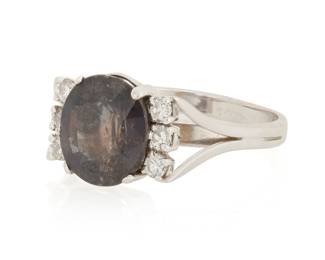 1040 A 14K White Gold and Color-Change Sapphire Ring Centering an oval color-change sapphire weighing approximately 3.40 carats, accented by six round diamonds  Size: 7 1/4 4.1 grams gross Estimate: $1,500 - $2,000