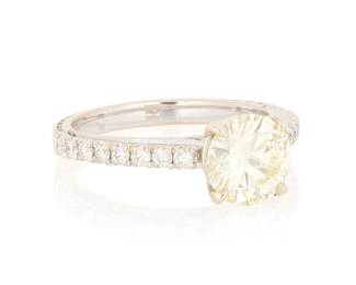 1146 A 14K White Gold and Diamond Ring Centering a round diamond weighing approximately 1.80 carats flanked by rows of round diamonds  Size: 6 3/4 3.4 grams gross Estimate: $3,500 - $5,500