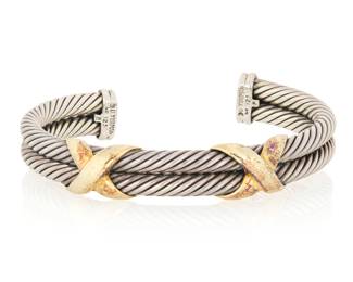 1077 David Yurman: Sterling Silver and 14K Gold Bangle Of twisted sterling silver cable design, accented with 14k yellow gold double X motifs. Signed David Yurman  Measures: 6 3/4 50.0 grams gross Estimate: $500 - $700