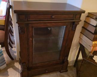 Elegant carved wood curio cabinet with glass sides, shelves and drawers.