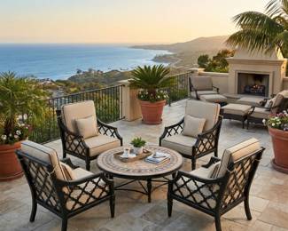 Round patio table with cushioned outdoor armchairs, decorative metal conversation seating and balcony furniture.