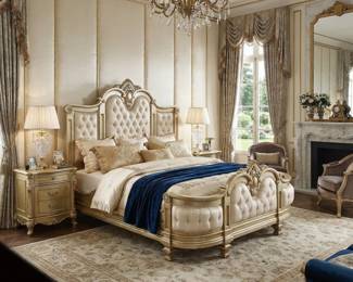 Ornate upholstered bed with a carved headboard, matching bedroom furniture and a tufted bench for a traditional bedroom.