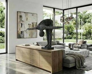 Large abstract human figure sculpture in a balancing pose, contemporary sculptural art and modern console table decor.