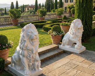 Pair of white lion statues on pedestal bases, guardian lion sculptures and formal garden or entrance decor.