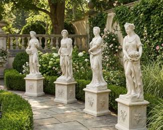 Classical female garden statues on decorative pedestals, traditional outdoor sculpture and formal landscape accents.