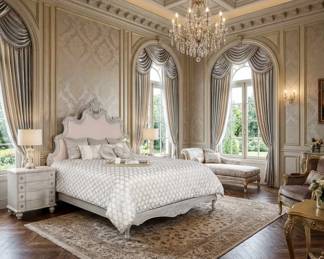 Ornate white upholstered bed with a carved headboard, matching nightstands and elegant traditional bedroom furniture.