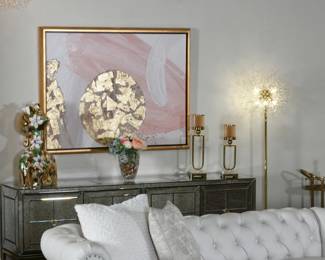 Mirrored sideboard with abstract wall art and decorative candle holders, glam living room storage and console decor.