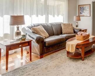 Matching end tables, brown leather sofa, oval coffee table, lamps