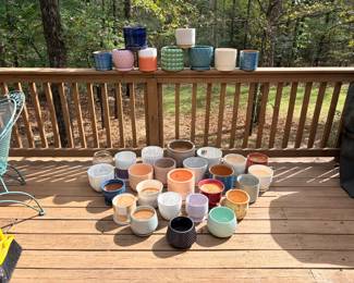Large Lot of Small Glazed Planters and Pots About thirty-five small and medium planters in pastel, glazed and textured designs, many with drainage saucers. A planter pot lot for succulents and houseplants. Some pots still have soil.