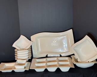 White Wave-Design Serving Dish Collection A lot of white glazed serveware with a curved wave design, including a large rectangular platter, square bowls, divided appetizer trays and a serving bowl. Contemporary serving pieces for buffets and entertaining. The glaze looks bright and even.