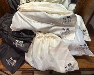 Coach Dust Bag Lot A lot of Coach Leatherware drawstring dust bags in cream and black, printed with the horse-and-carriage logo and "Est. 1941," in several sizes. These designer handbag dust bags are useful for storing purses or for anyone reselling Coach bags.