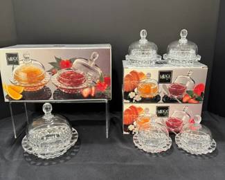 Mikasa Domed Jam and Butter Dishes with Boxes A set of Mikasa clear glass covered dishes with domes and scalloped saucer bases, shown with their Mikasa boxes. Useful domed dishes for jam, butter or brunch service. The glass appears clear in the photo.