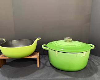 Le Creuset Green Oval Dutch Oven and Green Enameled Two-Handled Dish A green oval Le Creuset Dutch oven with an embossed lid and stainless knob, plus a lime green enameled two-handled balti or wok-style dish. Bright enameled cookware for stovetop and oven cooking.
