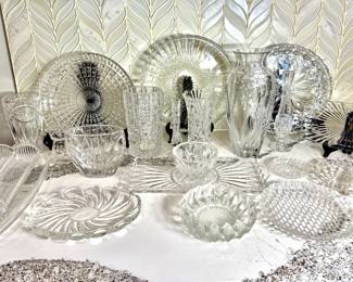 Pressed and Cut Glass Serving Pieces and Vase Lot A large lot of clear pressed and cut glass, including platters, round serving plates, bowls, a relish tray, candy dishes and several vases in various heights. Sparkling glass serveware for entertaining or table decor.