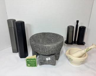 Molcajete Mortar and Pestle, Pepper Mills and Ceramic Mortar A stone molcajete mortar and pestle with its tag, a ceramic mortar and pestle with green botanical decoration, two tall hexagonal grinders and a matching grinder set on a stand. A handy spice prep lot for the kitchen.